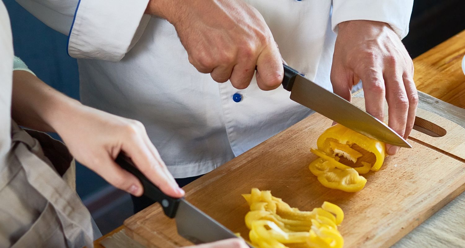 Zwei Köche in Küchen schneiden Paprika im Gourmet Hotel