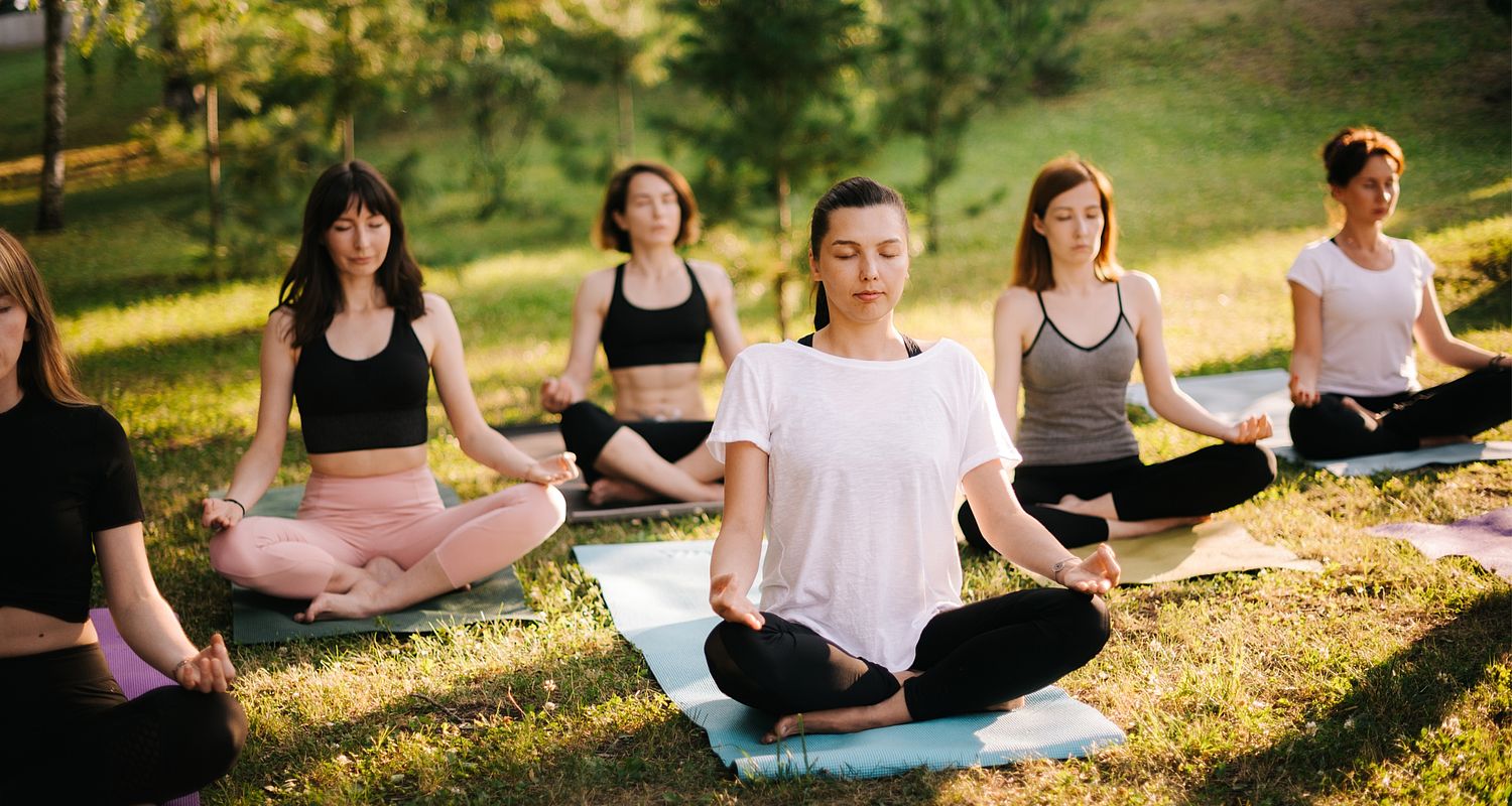 Gruppo di donne che fa yoga all'aperto presso l'hotel del benessere